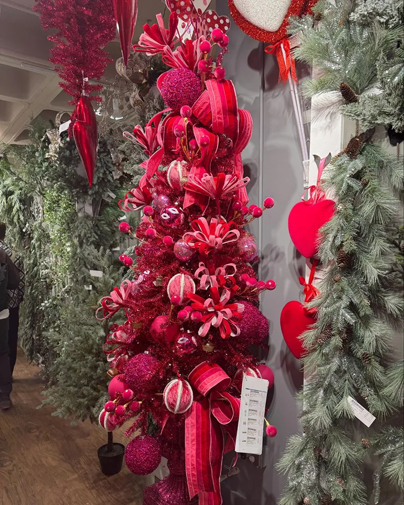 Crimson Christmas tree decorated with velvet ribbons and pink accents.