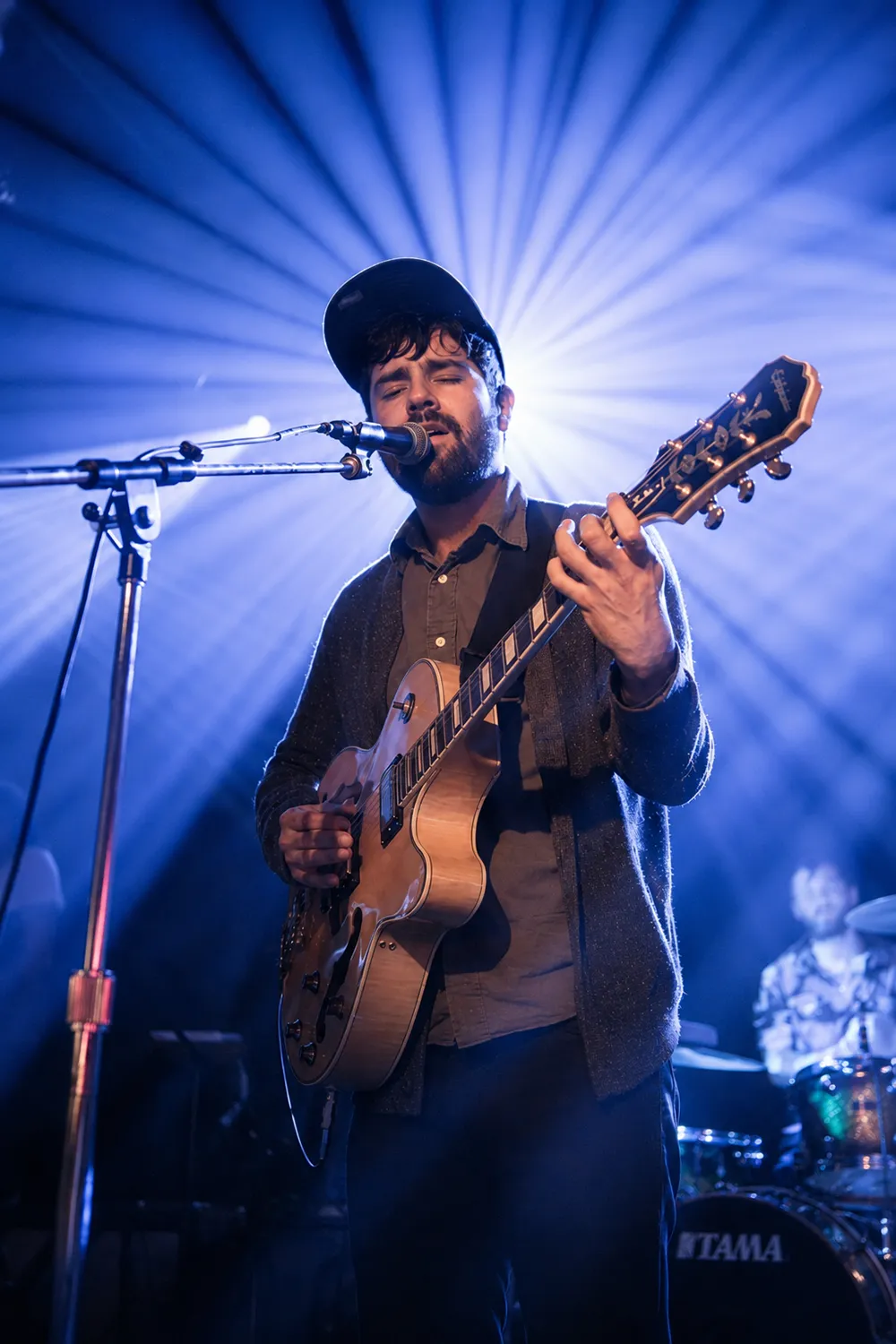Portrait of Sal performing on stage with a guitar.