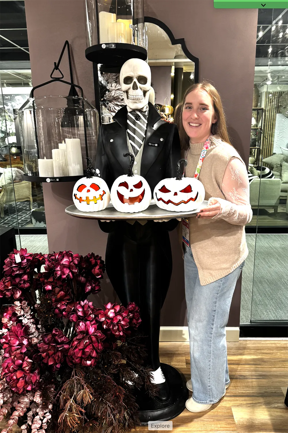 Photo of Tori and a dark magenta floral display and Halloween skeleton statue.